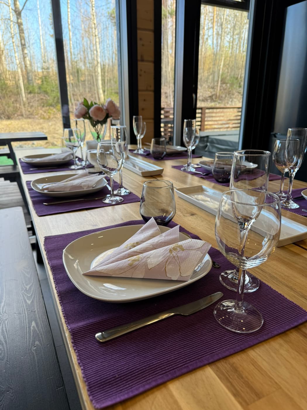 Ruokapöytä katettuna violetein tabletein Himos Airin huvilassa